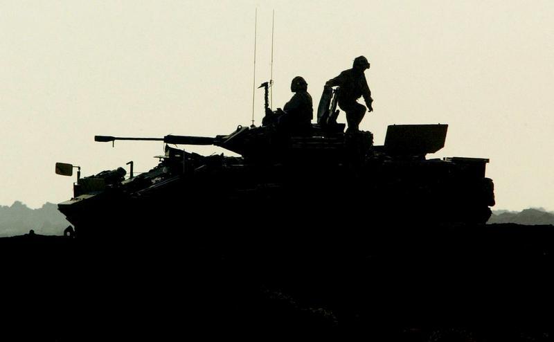 جنود بريطانيون يحضرون عربتهم المدرعة لإجراء دورية في منطقة  أحمد الأحمدي، 30 ميل جنوب غرب بغداد، 5 نوفمبر/تشرين الثاني 2004.