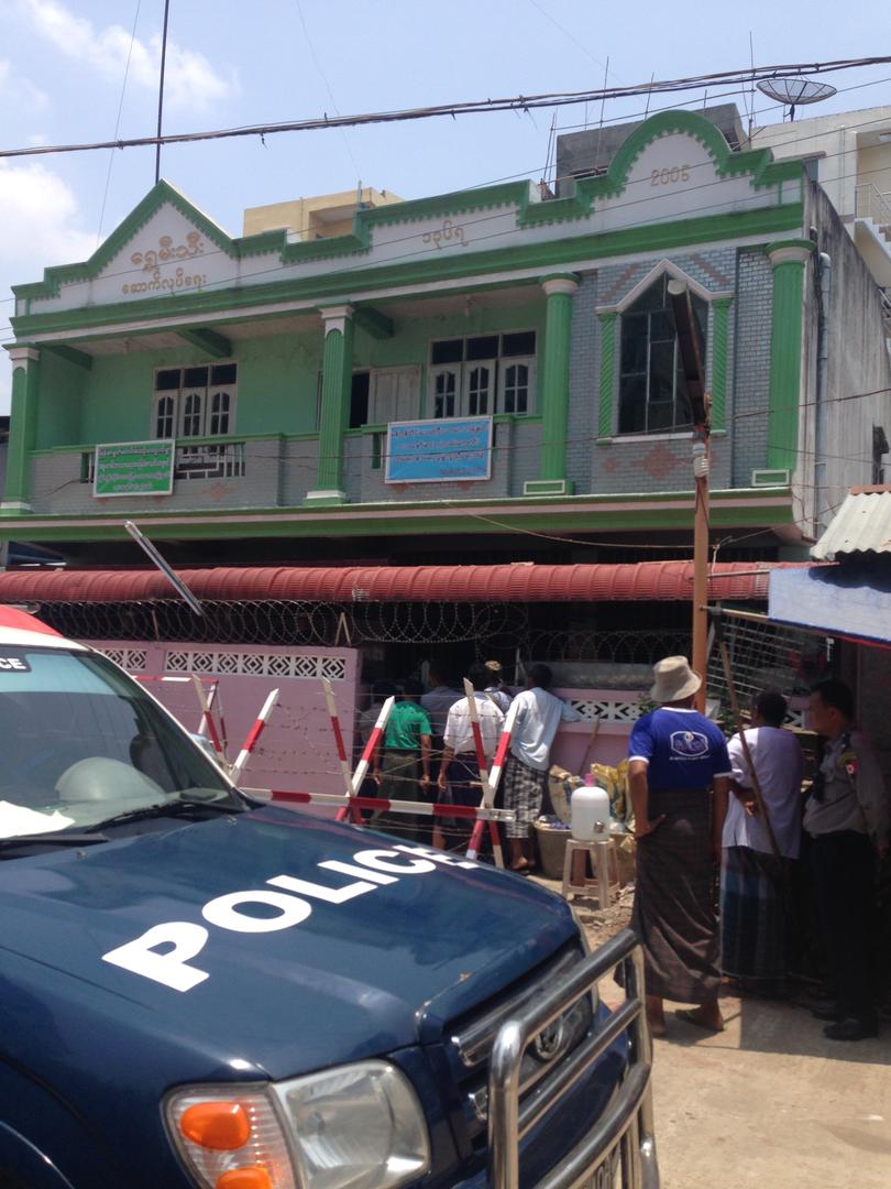 سكان محليون يراقبون من خلال أبواب مغلقة قيام السلطات، مصحوبة بشيوخ المدرسة وقوميين بوذيين متشددين، بتفتيش احدى المدارس المغلقة في بلدة ثاكيتا، رانغون، 29 أبريل/نيسان 2017.