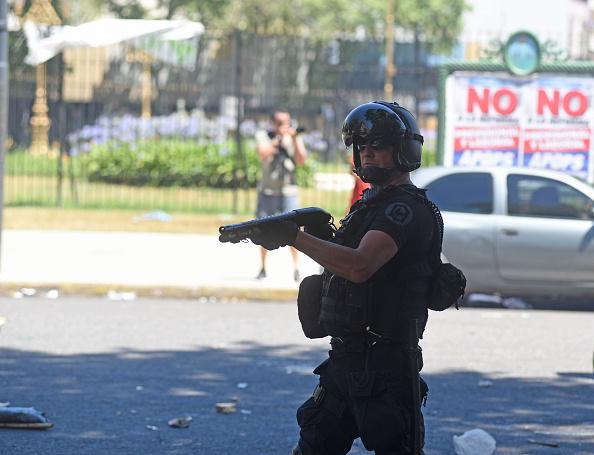 Un gendarme argentino apunta hacia manifestantes durante una manifestación contra una reforma propuesta por el gobierno frente al Congreso Nacional en Buenos Aires.