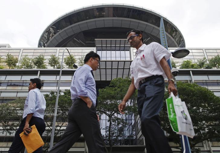 Des passants marchent devant le siège de la Cour suprême de Singapour, le 22 janvier 2014.