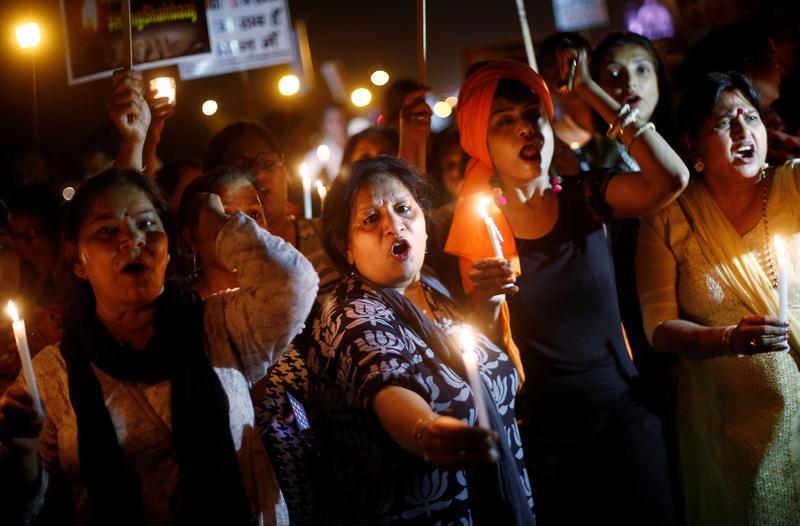 Women hold candles as they shout slogans during a protest against the rape of a ten-year-old girl, in the outskirts of Delhi, India April 25, 2018. 