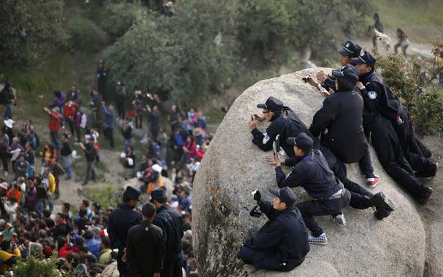 Chinese police photograph the crowd at the ceremonial unfolding of a giant thangka, or religious silk embroidery, during the Shoton Festival at Drepung Monastery on the outskirts of Lhasa, Tibet Autonomous Region, August 29, 2011.