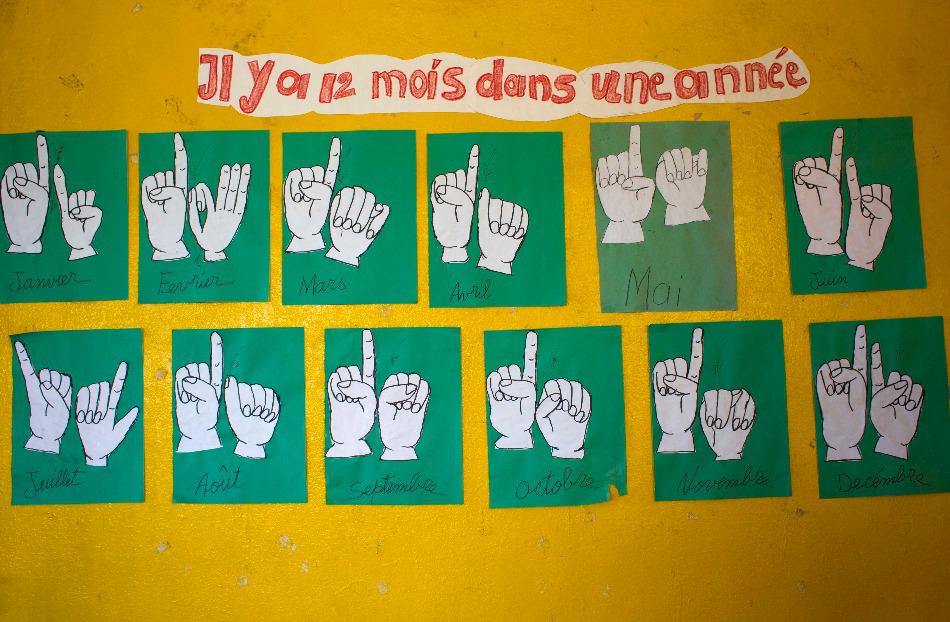 Une affiche montrant les signes manuels qui représentent les noms des 12 mois de l’année, photographiée le 17 avril 2016 dans une salle de classe pour élèves sourds dans le village de Lévêque (commune de Cabaret), au nord-ouest de Port-au-Prince, à Haïti.