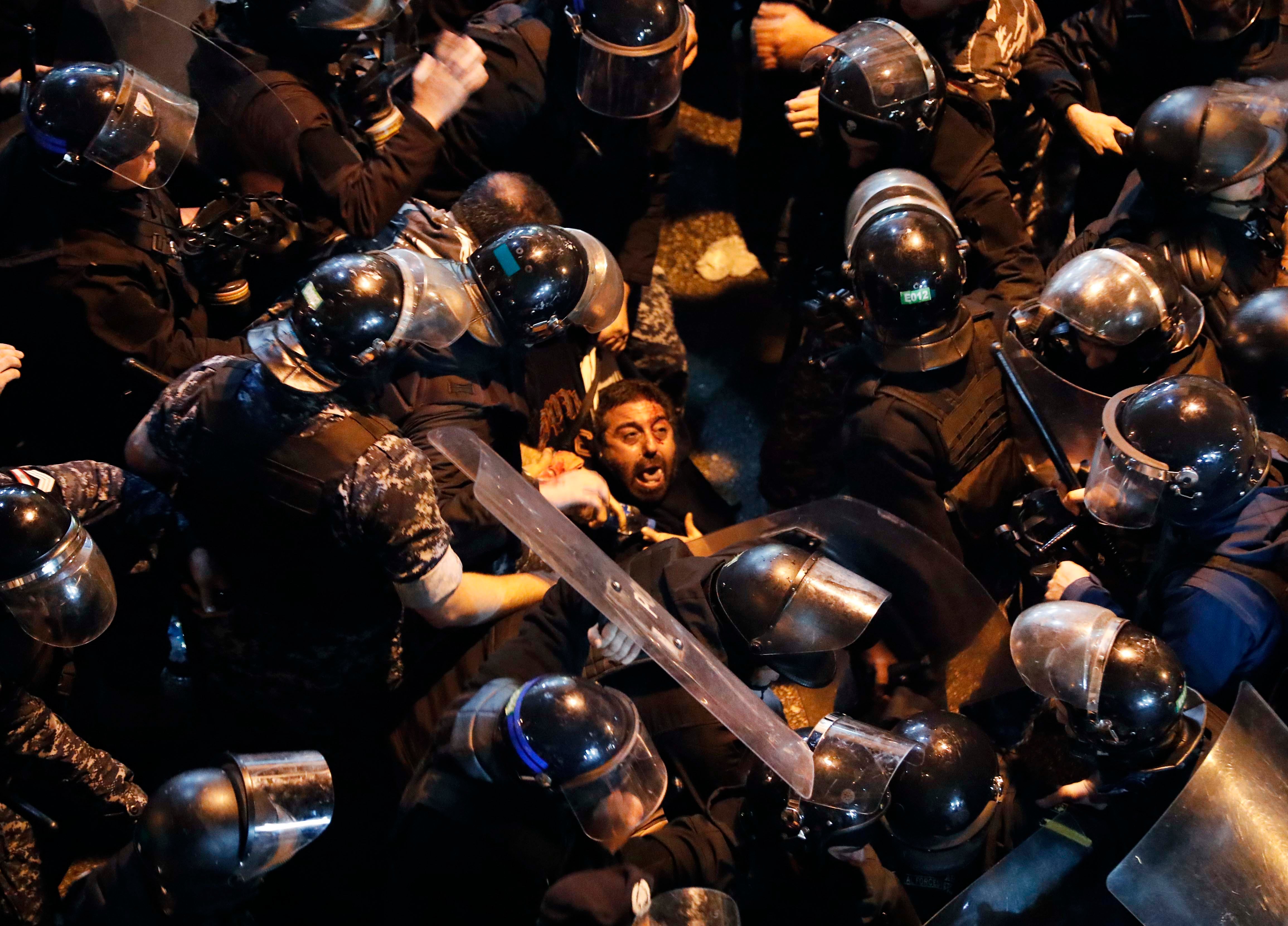 Riot police arrest a protester outside a police station in Beirut, Lebanon on Wednesday, January 15, 2020.