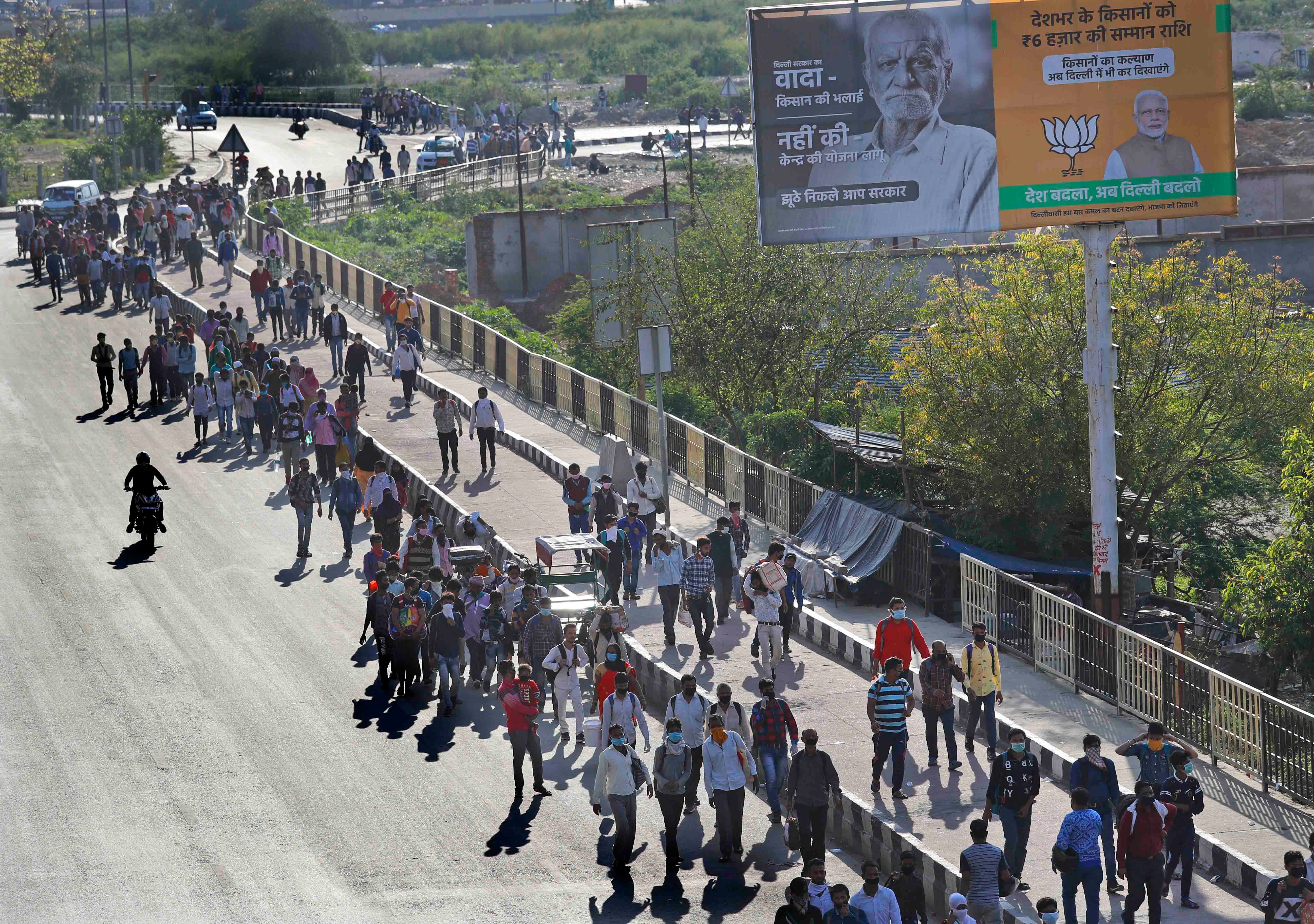 कोरोना वायरस के प्रसार को देखते हुए नई दिल्ली में लॉकडाउन के बाद अपने गांवों की ओर पैदल कूच करते प्रवासी मजदूर, भारत, 27 मार्च, 2020. © 2020 एपी फोटो/मनीष स्वरूप