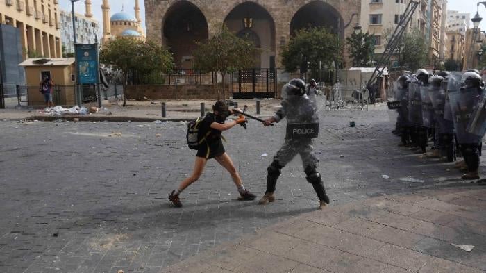 A policeman strikes a protester during anti-government demonstrations on August 8, 2020 in Beirut, Lebanon.