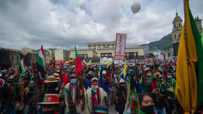 People march holding banners and flags