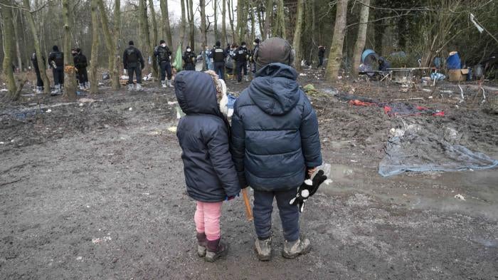 Deux enfants regardent la police saisir leur tente durant l’expulsion d’un campement à Grande-Synthe, dans le nord de la France, le 21 janvier 2021.