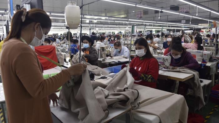Garment workers make clothes at a factory in Phnom Penh, Cambodia, December 17, 2021.