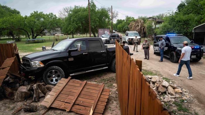 A truck shown after crashing through a wood fence 