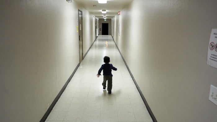 A small child runs down a hallway