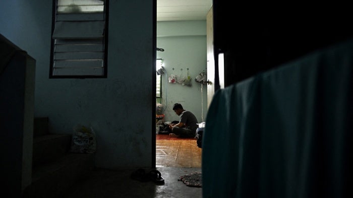 A man sits inside his apartment.
