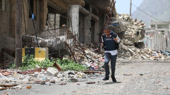 A journalist running down a city street