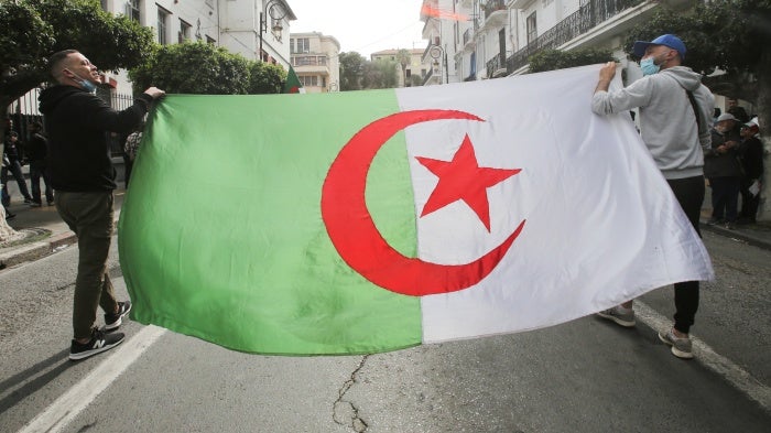 Demonstrators carry an Algerian flag in Algiers, Algeria, April 2, 2021.