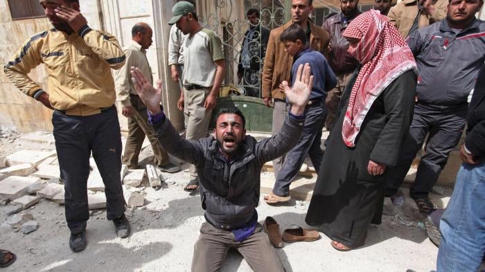 A man is overcome with grief in front of a destroyed mosque in Taftanaz where local residents gathered those killed after government forces attacked the town on April 3 and 4. 
