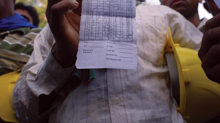 Migrant workers in Manama show their monthly timecards indicating hours they worked, but for which, they say, they have not been compensated. Unpaid wages is one of the most common human rights abuses migrant workers face.