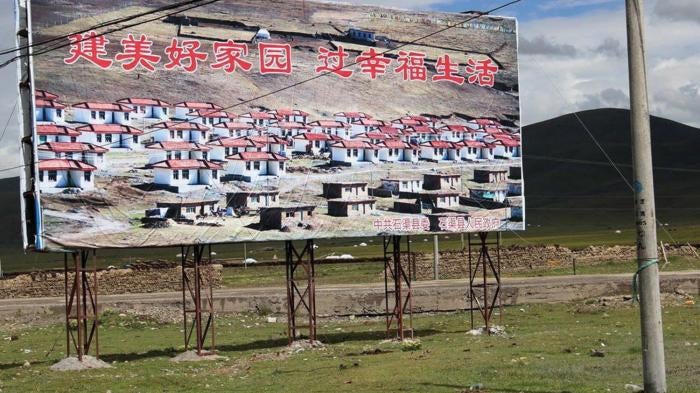 A propaganda billboard featuring a "New Socialist Village" in Sershul (Shiqu) County, Sichuan Province.  The billboard reads: "Build Beautiful Homeland, Live a Happy Life"