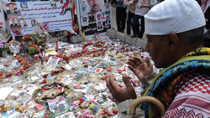 A ceremony honoring those killed in the Friday of Dignity massacre in Sanaa, Yemen, on March 18, 2011, held one week later at the site of the killings.  The text on the posters contains a prayer and names of the dead.