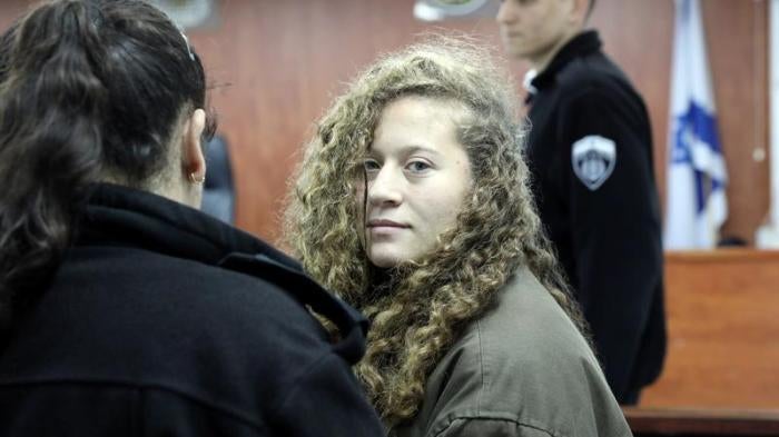 Palestinian teen Ahed Tamimi enters a military courtroom escorted by Israeli Prison Service personnel at Ofer Prison, near the West Bank city of Ramallah, January 1, 2018. © 2018 Reuters