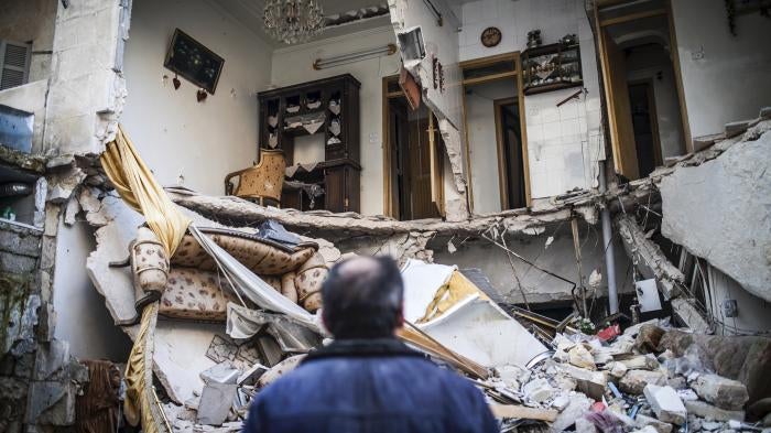 A civilian looks at a destroyed home in Aleppo, Syria, January 3, 2013. © 2013 AP Photo/Andoni Lubaki