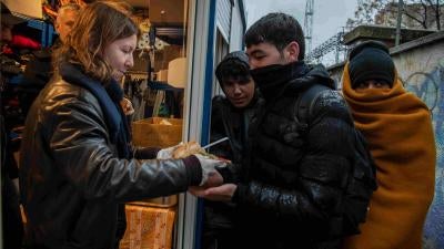 Freiwillige der Caritas und des Jesuiten-Flüchtlingsdienstes verteilen Mahlzeiten an Asylsuchende und Migrant*innen am Bahnhof in Rijeka, Kroatien. 