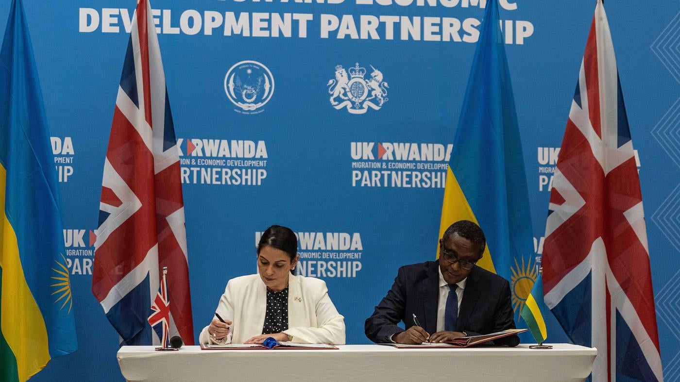 Then-British Home Secretary Priti Patel (L), and Rwandan Minister of Foreign Affairs and International Cooperation Vincent Biruta sign an agreement