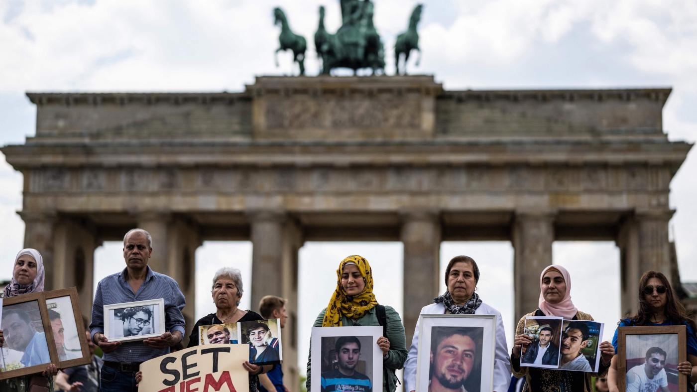  Des proches de Syriens détenus par le gouvernement syrien, et/ou victimes de «&nbsp;disparitions&nbsp;», tenaient leurs photos lors d'un rassemblement tenu pour appeler à leur libération, devant la porte de Brandebourg à Berlin, le 7 mai 2022.
 © 2022 John MacDougall/AFP/Getty Images