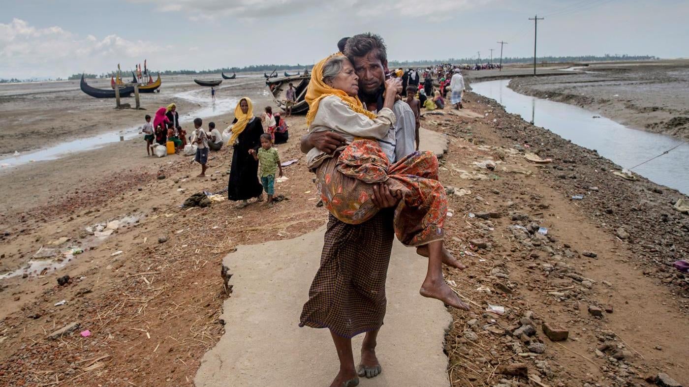 Abdul Kareem, a Rohingya Muslim, carries his mother, Alima Khatoon, to a refugee camp after crossing from Burma into Bangladesh on Sept. 16, 2017.