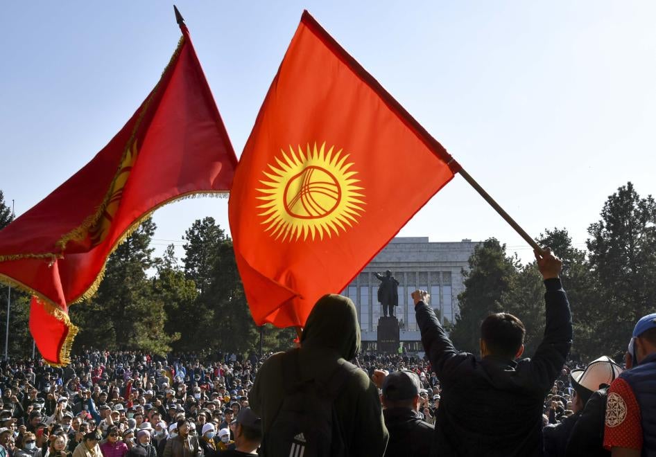 Protesters react waving Kyrgyz national flags as they wait for Kyrgyz Prime Minister Sadyr Zhaparov speech in front of the government building in Bishkek, Kyrgyzstan, Wednesday, Oct. 14, 2020.