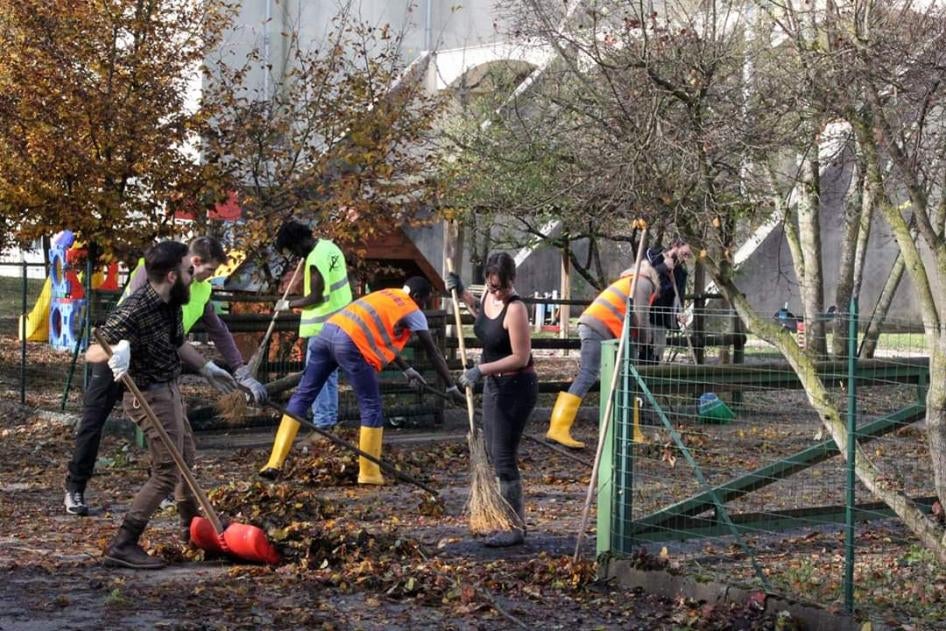 Italians and asylum seekers from the local specialized reception center work together to clear debris after floods in Belluno, Italy, November 2018. 