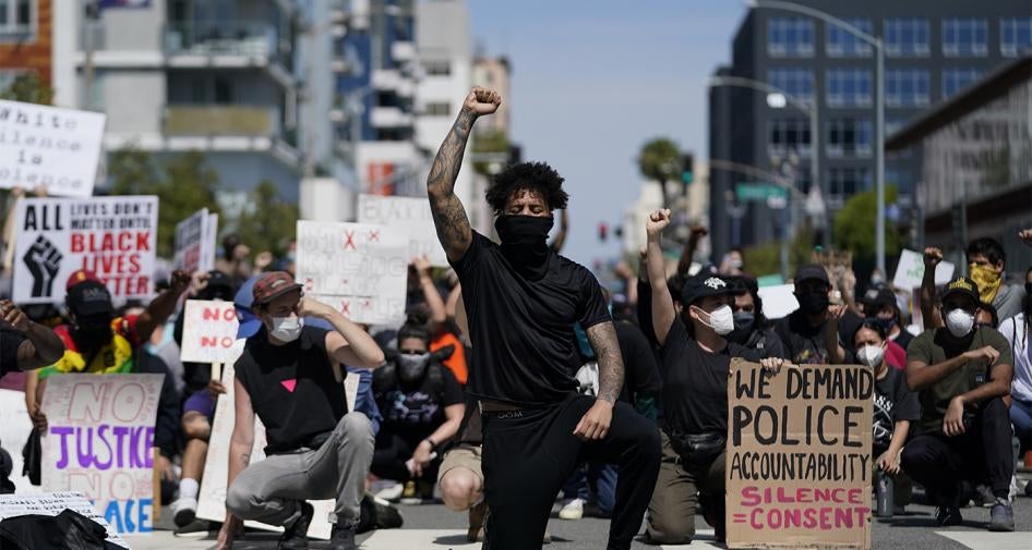 Demonstrators kneel outside the Long Beach Police Department in Long Beach, California during a protest on May 31, 2020. 