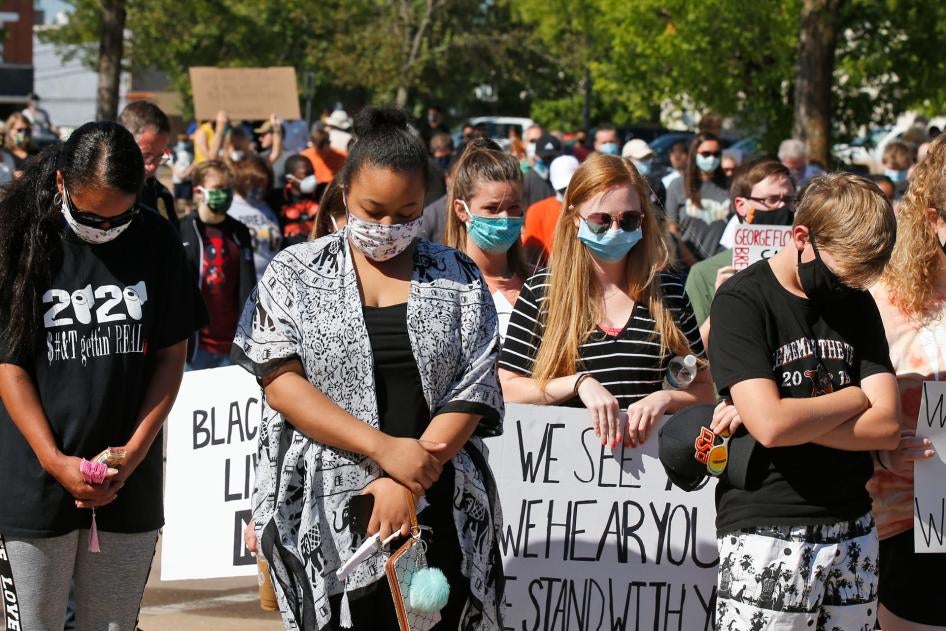 People bow their heads during a rally to protest the death of George Floyd, June 3, 2020, in Stillwater, Oklahoma.