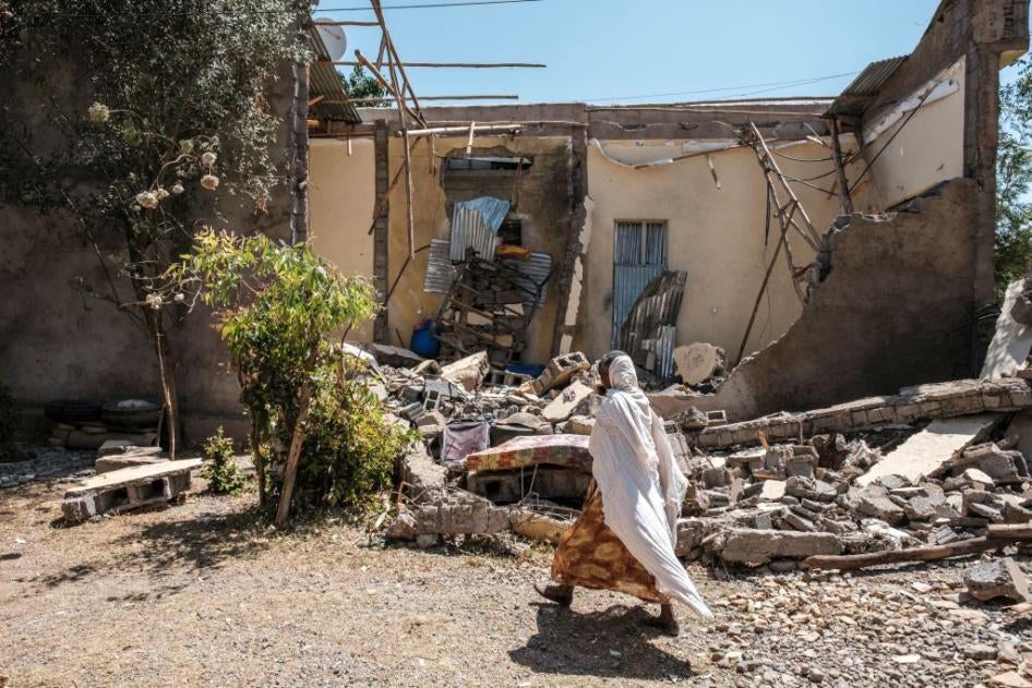 A woman walks past a house that was damaged by shelling when federal-aligned forces entered the town of Wukro, in Ethiopia's Tigray region, March 1, 2021. 