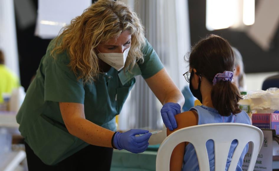 A nurse with a syringe explains and calms a girl while the COVID-19 vaccination goes on for children and young people in Granada, Spain on September 03, 2021. 
