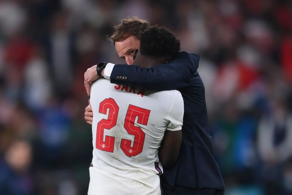 England’s Bukayo Saka (left) is consoled by England's manager Gareth Southgate (right) after the Euro 2020 soccer final match between England and Italy at Wembley stadium in London on July 11, 2021.