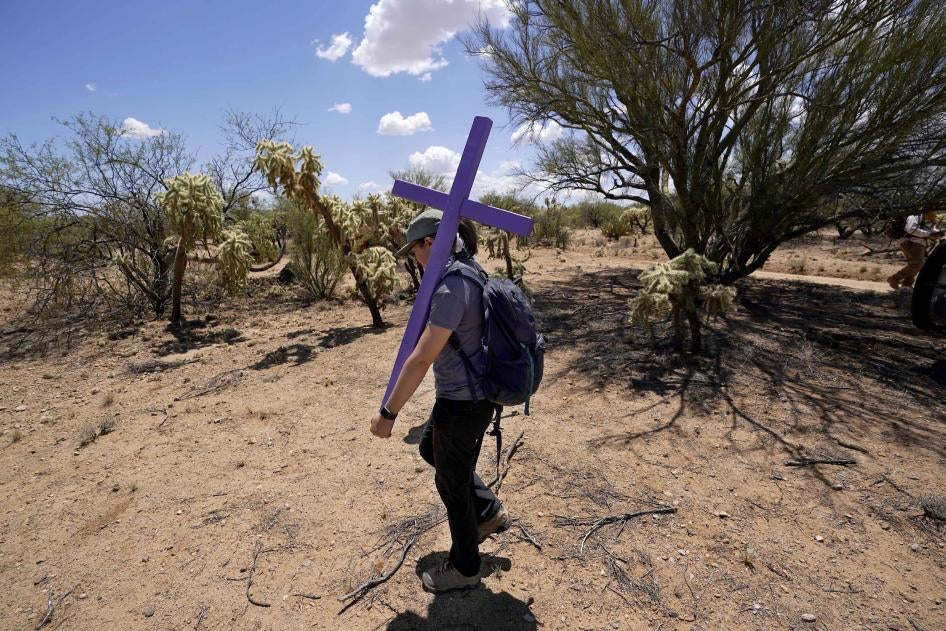 Alyssa Quintanilla, part of the Tucson Samaritans volunteer group, carries a cross, May 18, 2021, to be installed near Three Points, Arizona. The cross will be installed in the desert to commemorate the death of a migrant there. 