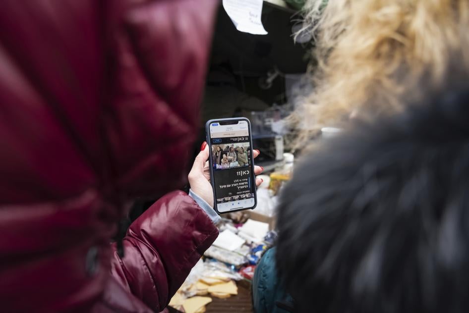 Two women from Kharkiv, Ukraine, watch news on a mobile phone, just after having crossed the border into Moldova, on March 10, 2022.