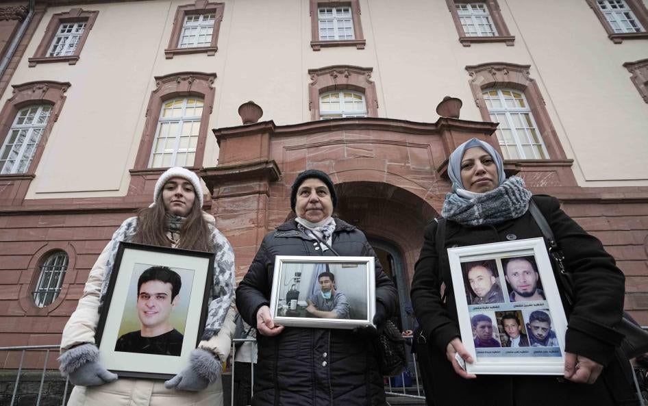 3 women hold framed photographs