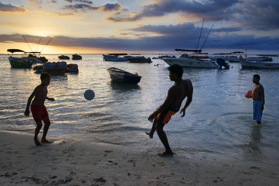 Children playing at sunset at Trou aux Biches in Mauritius. 
