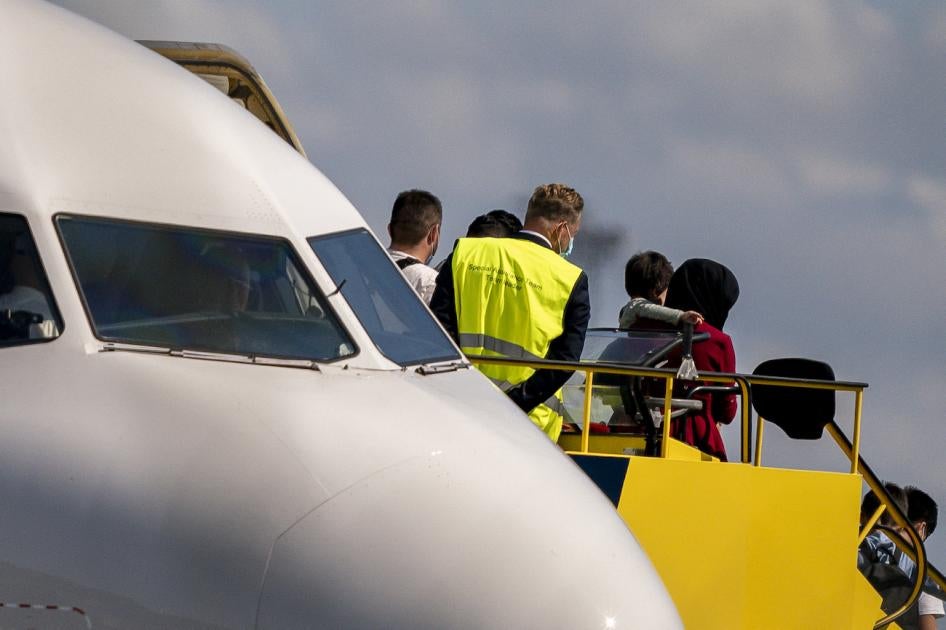 An Afghan woman carries a child as she disembarks at Copenhagen Airport.