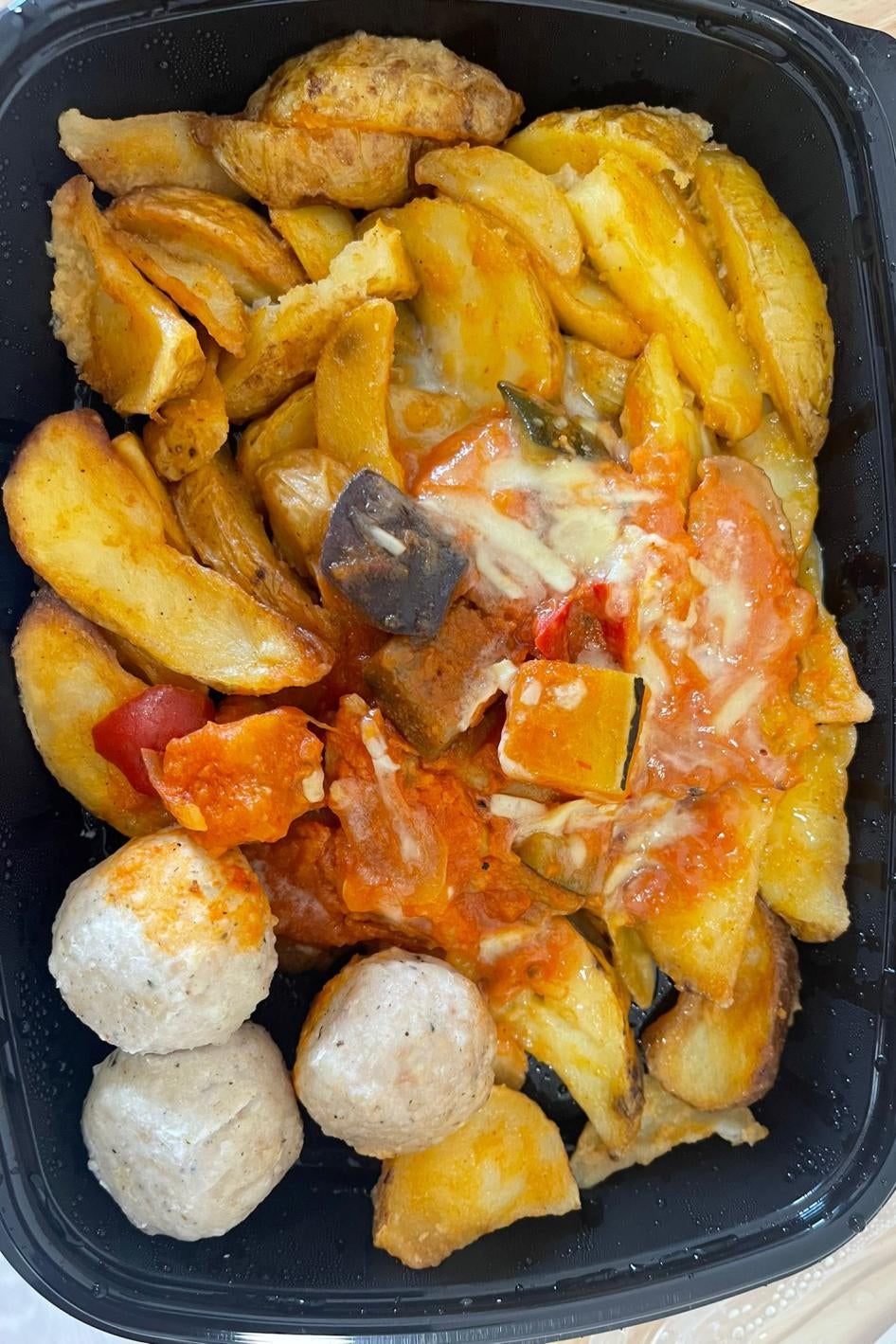 Potatoes, meat, and sauce in a container