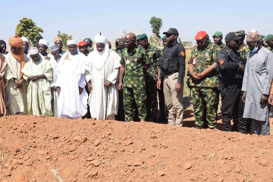 Nigerian Chief of Army Staff Lt. Gen. Taoreed Lagbaja, center, with other community leaders at the grave side where victims of an army drone attack were buried in Tudun Biri village, Nigeria, December 5, 2023.
