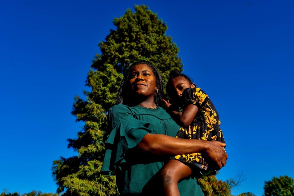 A woman poses for a photo holding her son