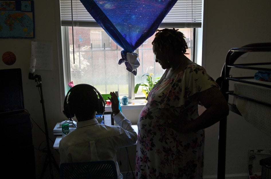 A pregnant woman checks in on her son in their apartment in Washington, DC. during the Covid-19 pandemic,  July 14, 2020.