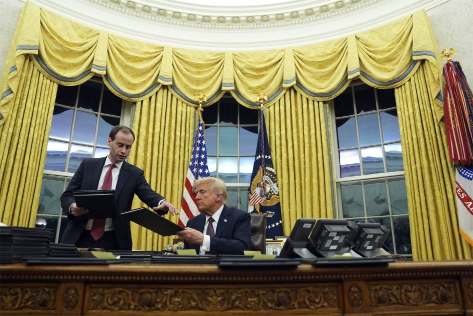 US President Donald Trump signs executive orders in the Oval Office of the White House in Washington DC, January 20, 2025. 
