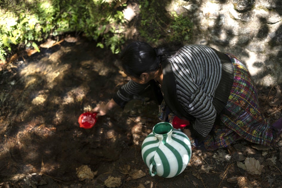 A woman collects water to drink from a well in Santa María Chiquimula municipality, Totonicapán department, Guatemala, March 11, 2025.