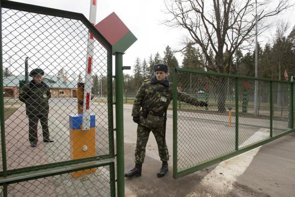 A Belarussian border guard closes the gate at a border crossing with Poland, near the village of Pererov, southwest of Minsk, March 31, 2015.
