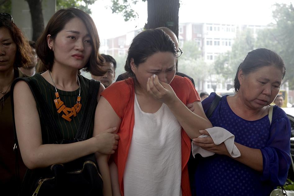Fan Lili, the wife of imprisoned activist Gou Hongguo, is escorted by Li Wenzu, the wife of imprisoned lawyer Wang Quanzhang, and another woman as they stage a protest outside the Tianjin No. 2 Intermediate People's Court in Tianjin, China on Monday, Augu
