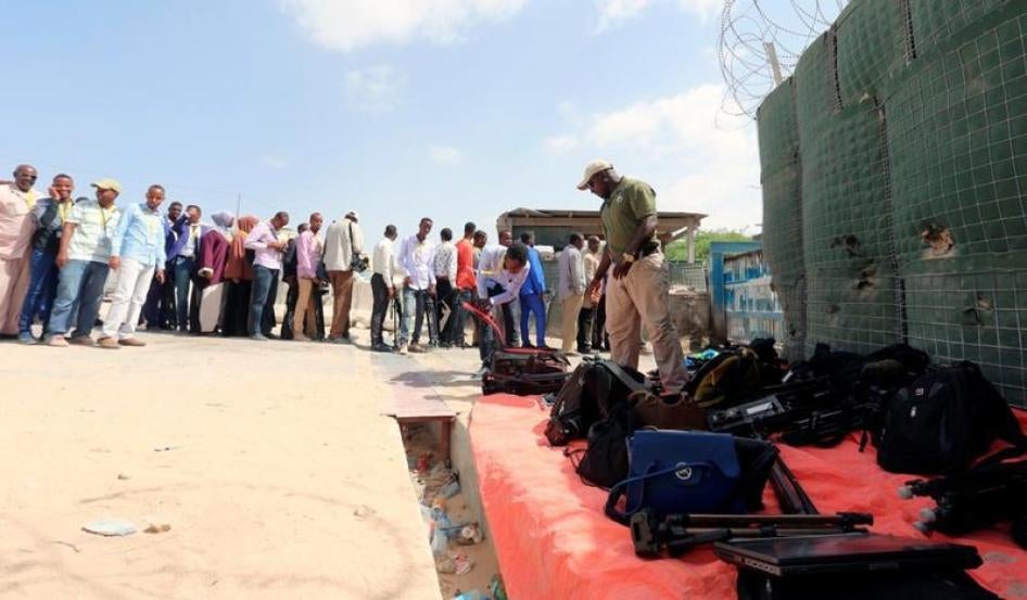 Journalists queue for a security sweep outside the venue of the presidential vote at the airport in Somalia's capital Mogadishu