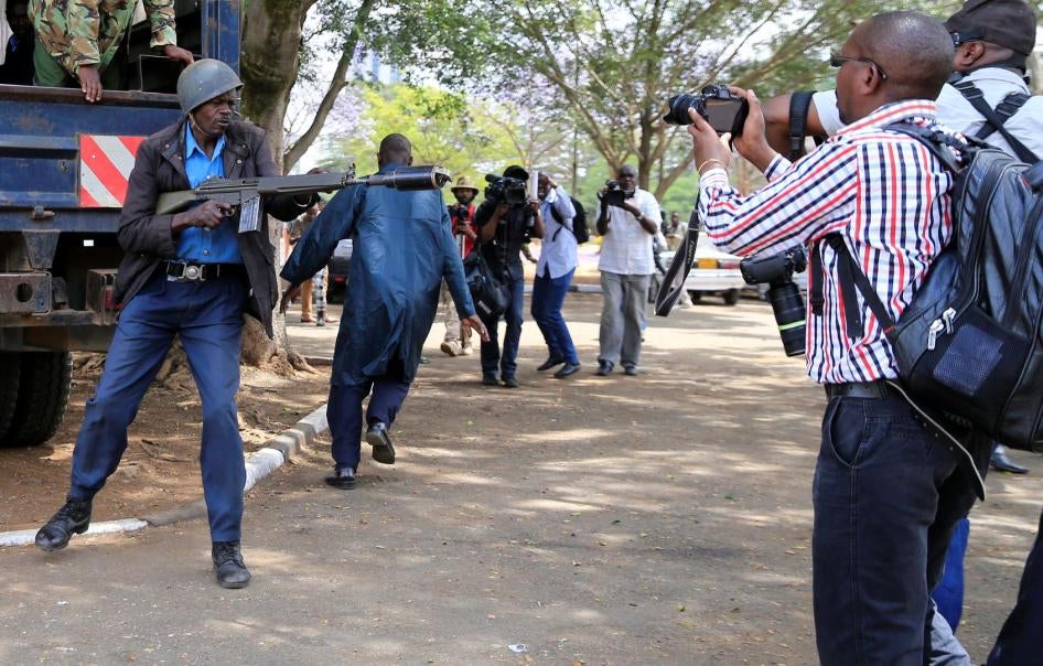 An anti-riot police officer aims a teargas canister while journalists cover an anti-corruption protest in Kenya's capital, Nairobi. November 3, 2016. 